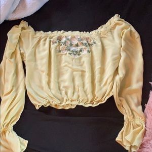 Yellow crop top with flowers. It’s not tight.